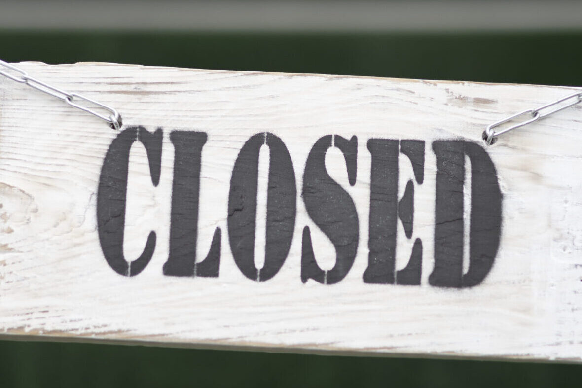 closed-sign-with-chains Eine Treppe, die mit einem Band gesperrt ist. An dem Band hängt ein Schild mit der Aufschrift "Closed".